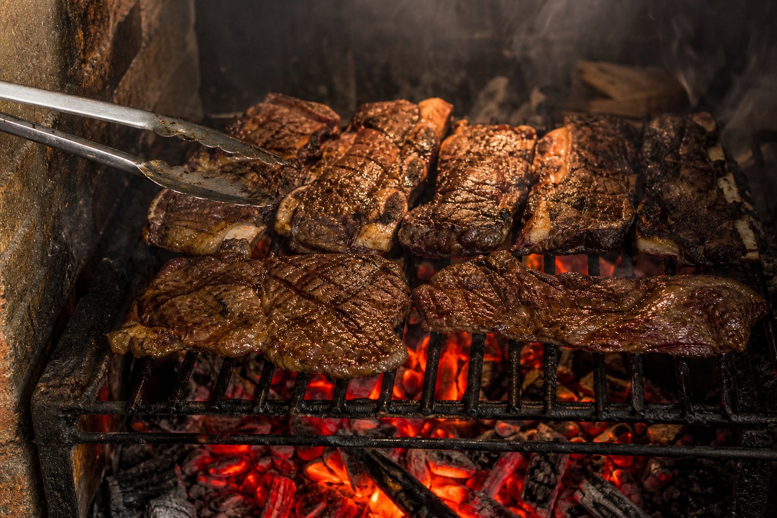 Cortes de res asándose sobre carbón encendido en el asador